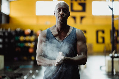 Athlete in a gym setting with a yellow wall and equipment in the background