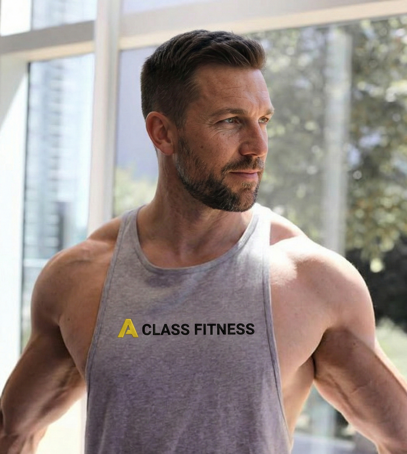 Man wearing a gray tank top with 'A Class Fitness' logo in a bright indoor setting.