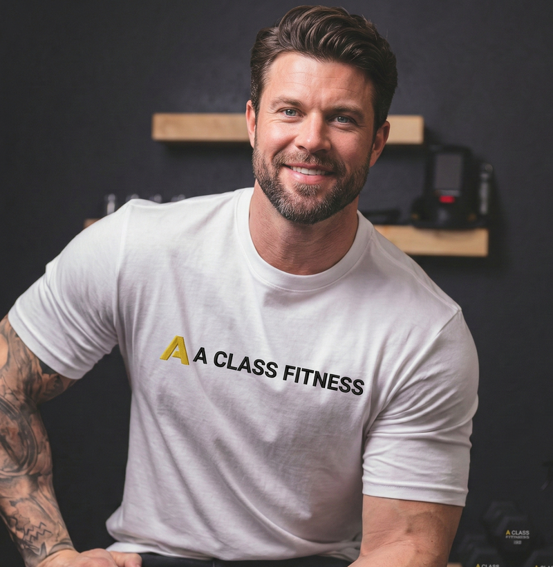 Man wearing a 'A Class Fitness' t-shirt sitting in a gym setting.